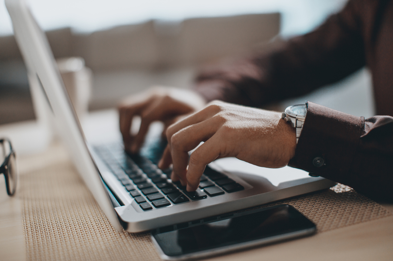 Close-up photo of hands typing on a laptop computer. 